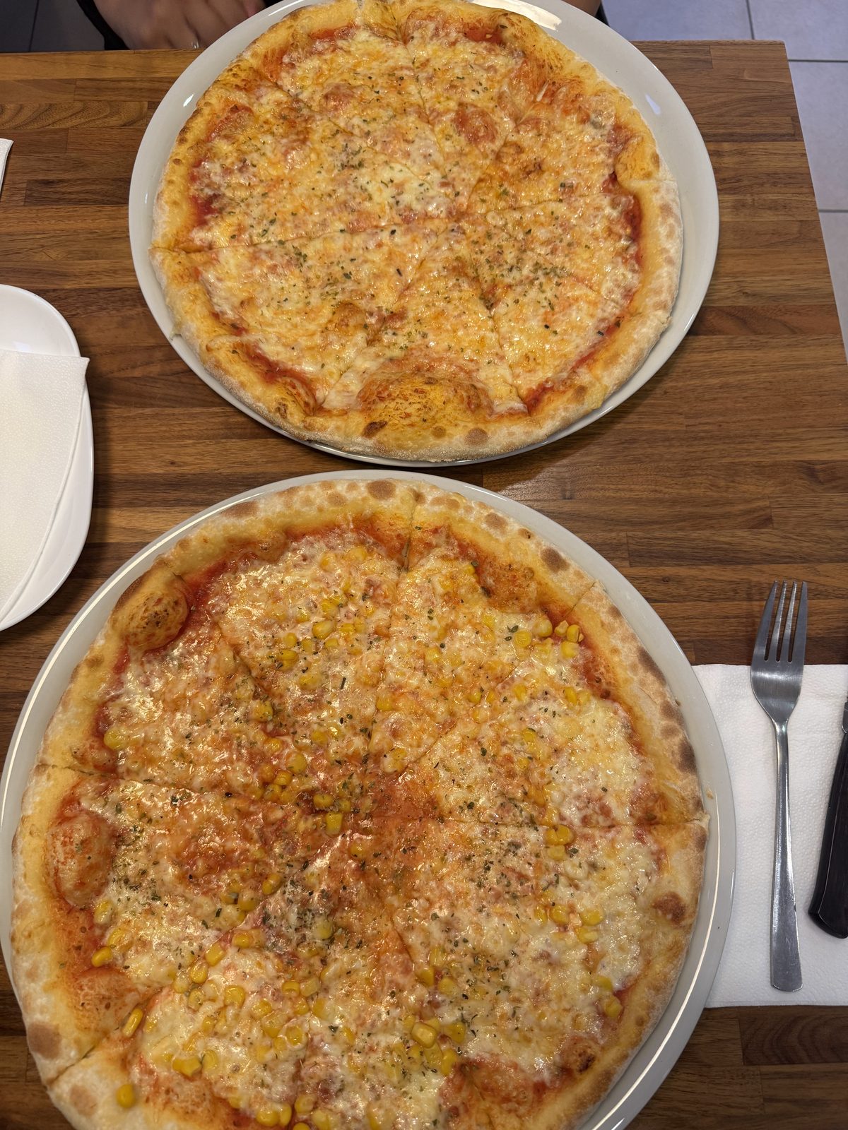 Käsepizza und Mais-Pizza frisch aus dem Steinofen